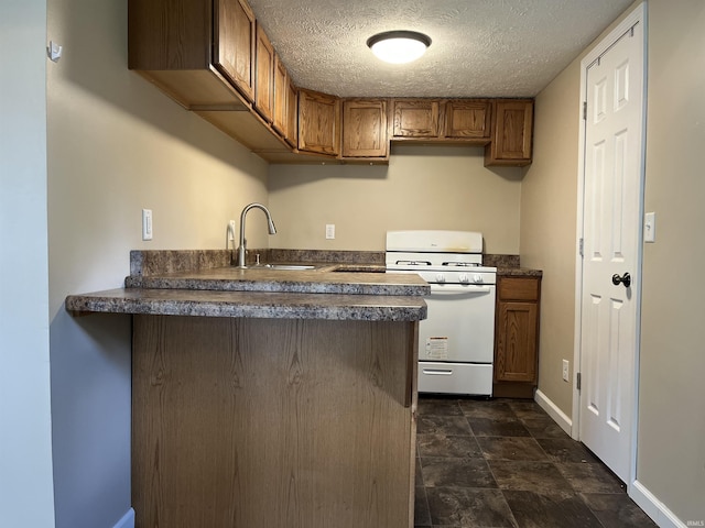 7374 W Upper Bensart Dr, Claypool, IN 46510 - kitchen with white gas stove, a sink, dark countertops, brown cabinets, and a textured ceiling