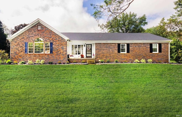 single story home featuring brick siding and a front yard