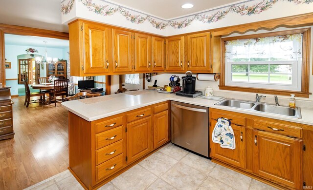 kitchen with dishwasher, a sink, and brown cabinetry