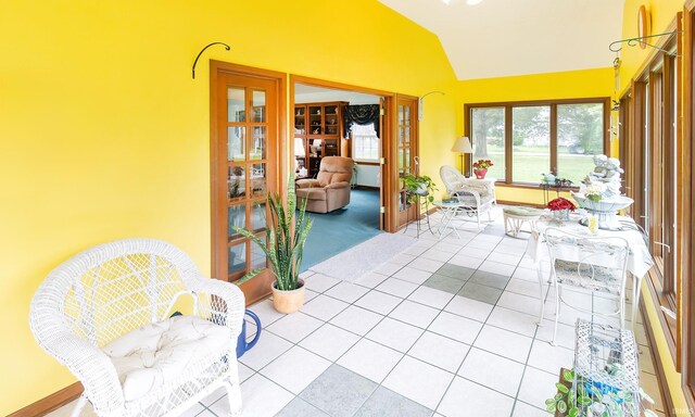 sunroom / solarium with lofted ceiling, french doors, and tile patterned floors