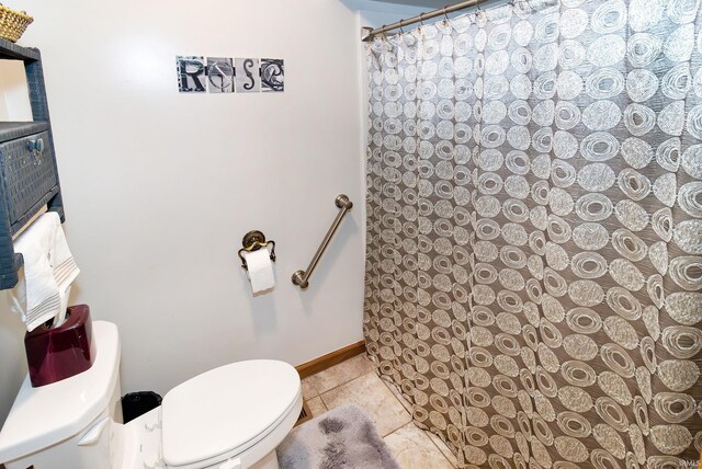 full bath featuring toilet, tile patterned flooring, and a shower with shower curtain
