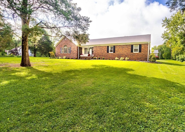 ranch-style home with a front yard and brick siding