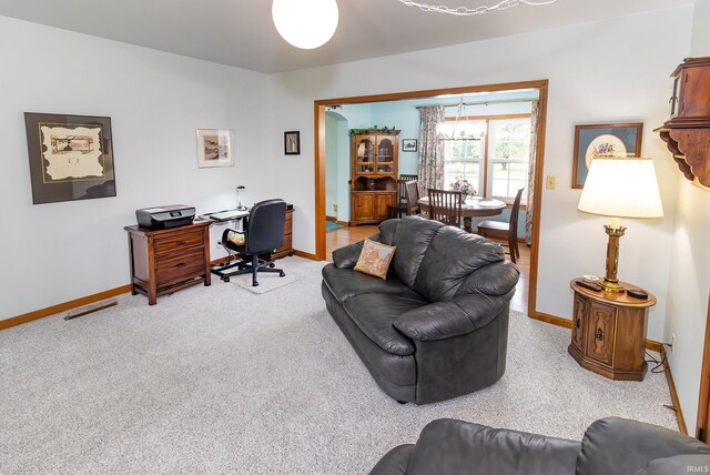 home office with baseboards and light colored carpet