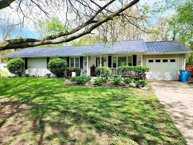 ranch-style house featuring a standing seam roof, an attached garage, and metal roof
