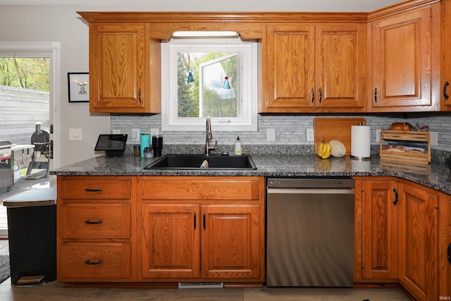 kitchen with dishwasher, a sink, plenty of natural light, and backsplash
