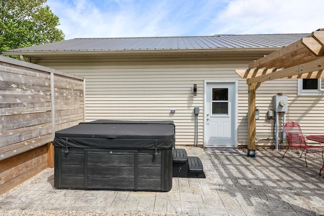 view of patio / terrace featuring a hot tub and fence