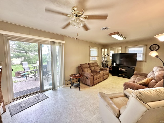 52 S 950 E, Greentown, IN 46936 - living area with healthy amount of natural light, a ceiling fan, a baseboard heating unit, and light tile patterned flooring