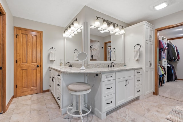 55961 Dana Dr, Bristol, IN 46507 - bathroom with baseboards, double vanity, a walk in closet, and marble finish floors