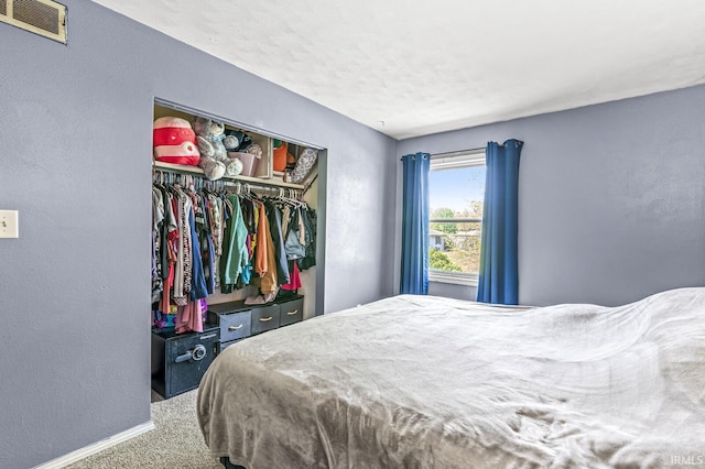 carpeted bedroom with baseboards, a closet, and a textured wall
