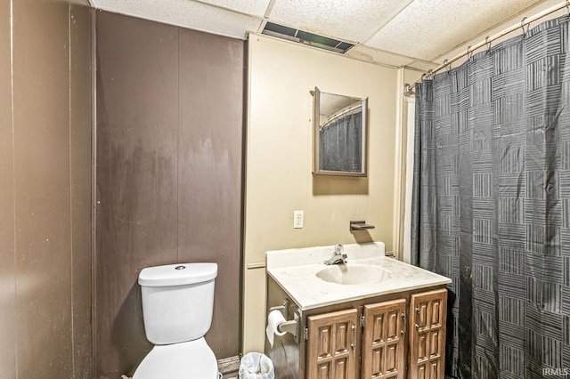 full bathroom featuring a drop ceiling, toilet, vanity, and a shower with shower curtain