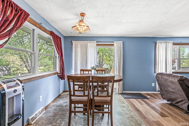 dining space featuring a textured ceiling, healthy amount of natural light, and baseboards