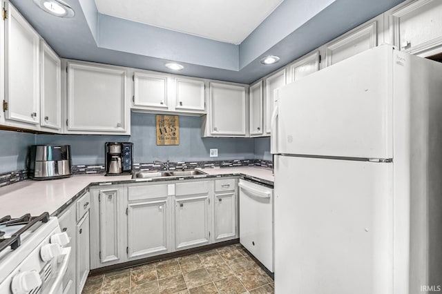 kitchen featuring white appliances, a sink, white cabinetry, stone finish floors, and recessed lighting