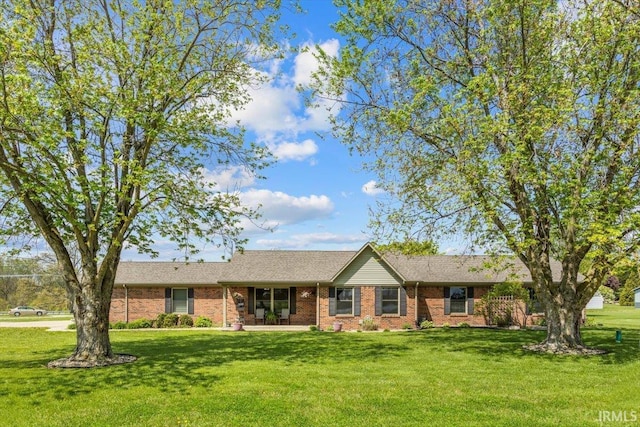 ranch-style home with a front yard and brick siding