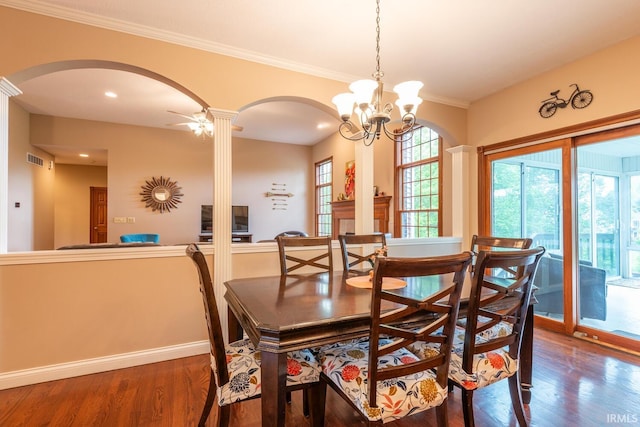 dining room with arched walkways, wood finished floors, baseboards, a chandelier, and ornate columns