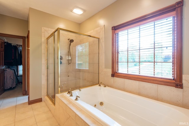 full bathroom with a stall shower, a jetted tub, tile patterned floors, and a spacious closet