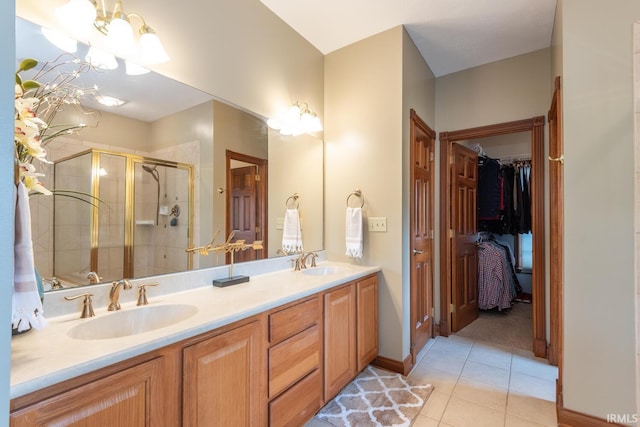 bathroom with tile patterned floors, a stall shower, double vanity, and a walk in closet