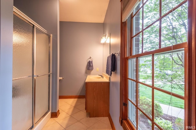 bathroom with tile patterned floors, a shower stall, vanity, and baseboards