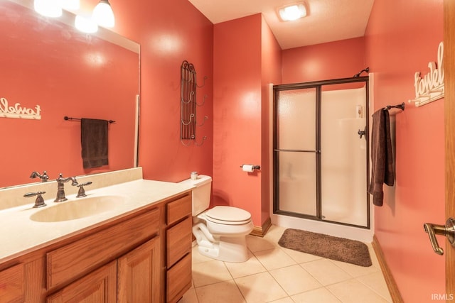 bathroom with a stall shower, tile patterned flooring, toilet, and vanity