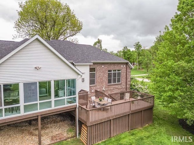 rear view of house with a deck and a shingled roof
