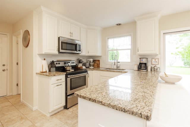 14375 Pheasant Ct, Mishawaka, IN 46545 - kitchen with appliances with stainless steel finishes, a sink, a peninsula, light stone countertops, and white cabinets