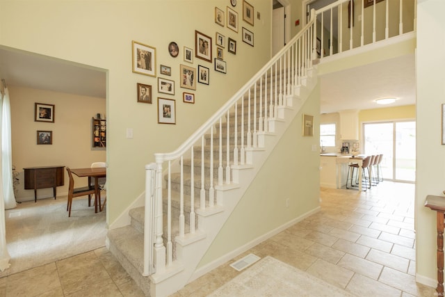 14375 Pheasant Ct, Mishawaka, IN 46545 - staircase featuring a high ceiling, baseboards, and tile patterned flooring