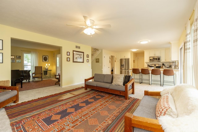 14375 Pheasant Ct, Mishawaka, IN 46545 - living room with ceiling fan, stairs, light carpet, and baseboards