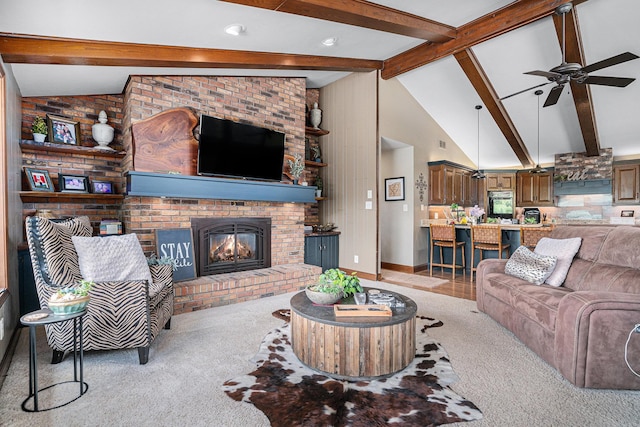 living area featuring light carpet, beam ceiling, a fireplace, a ceiling fan, and high vaulted ceiling