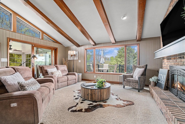 living area featuring wooden walls, a brick fireplace, and carpet flooring