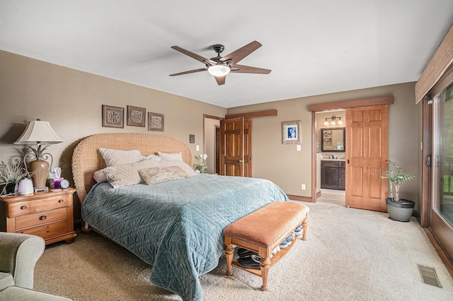 bedroom featuring light colored carpet, baseboards, ceiling fan, and connected bathroom