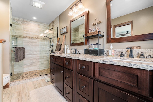 full bath featuring a shower stall, double vanity, recessed lighting, ceiling fan, and toilet