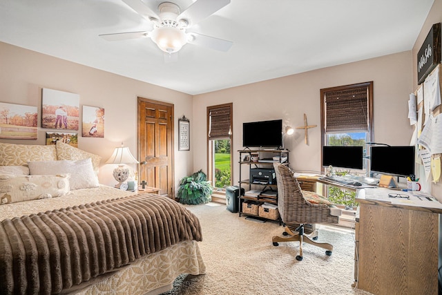carpeted bedroom with a desk and ceiling fan