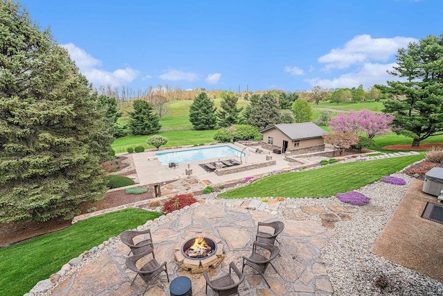 swimming pool featuring a patio area, an outdoor fire pit, and a lawn