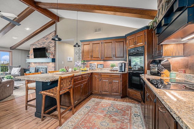 kitchen with black appliances, light wood-style floors, open floor plan, range hood, and recessed lighting