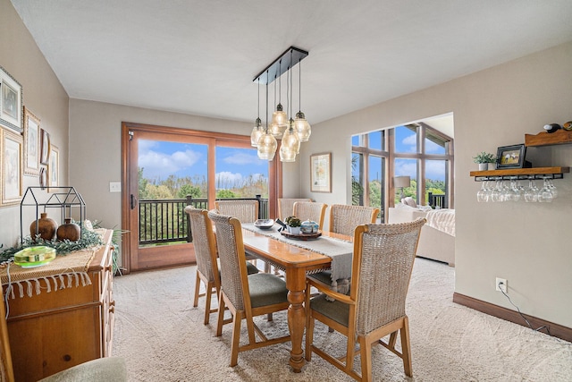 dining space featuring light colored carpet, plenty of natural light, and baseboards