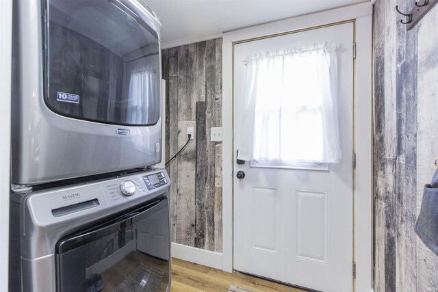 laundry room featuring stacked washing machine and dryer and wood finished floors