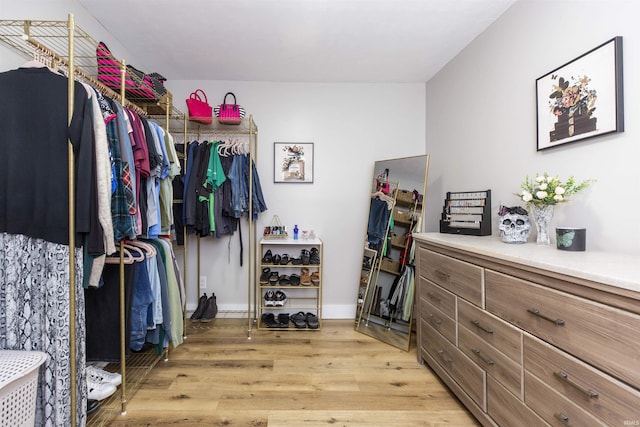 walk in closet with light wood-style floors