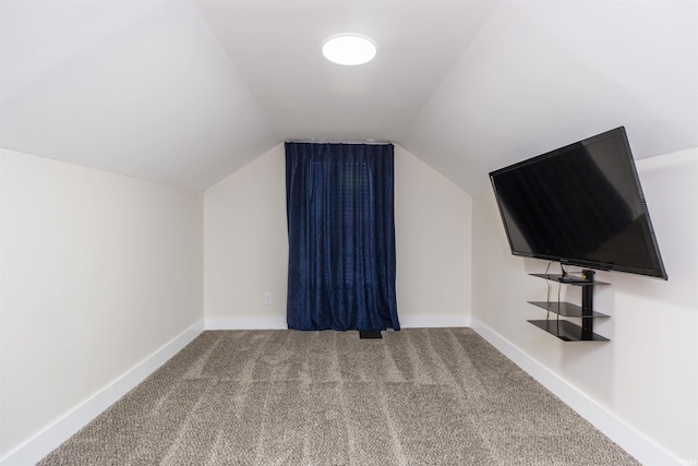 additional living space with carpet, lofted ceiling, and baseboards