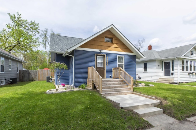 bungalow-style house featuring central AC and a shingled roof