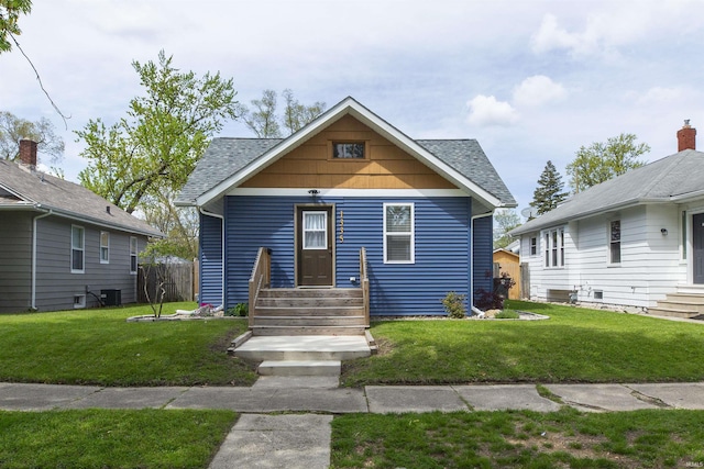 bungalow-style house with a front yard, entry steps, and a shingled roof