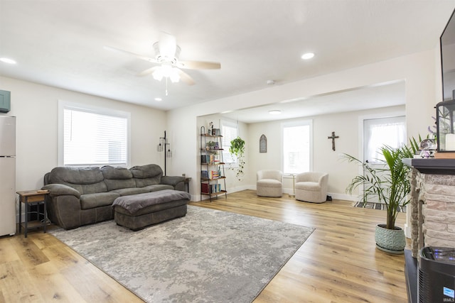 living area featuring a ceiling fan, light wood-type flooring, baseboards, and recessed lighting