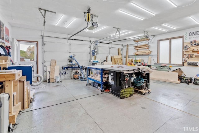garage with a garage door opener and a workshop area