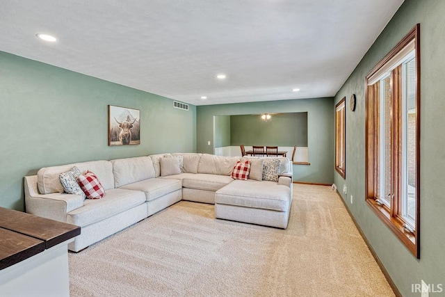 living room featuring light carpet, recessed lighting, and baseboards