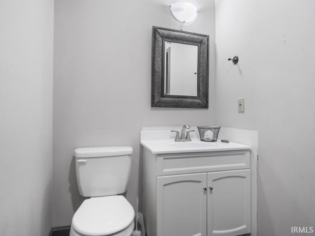 half bathroom featuring vanity and toilet