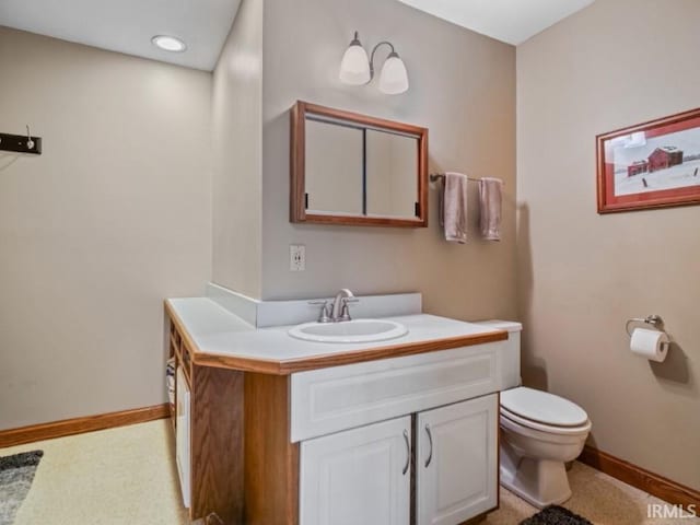bathroom featuring toilet, vanity, baseboards, and recessed lighting