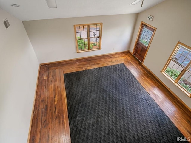 spare room featuring hardwood / wood-style flooring, lofted ceiling, and a ceiling fan