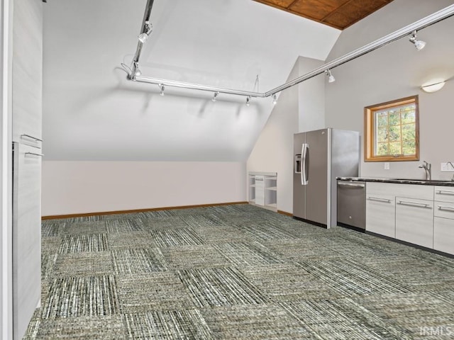 additional living space featuring a sink, vaulted ceiling, baseboards, and carpet floors