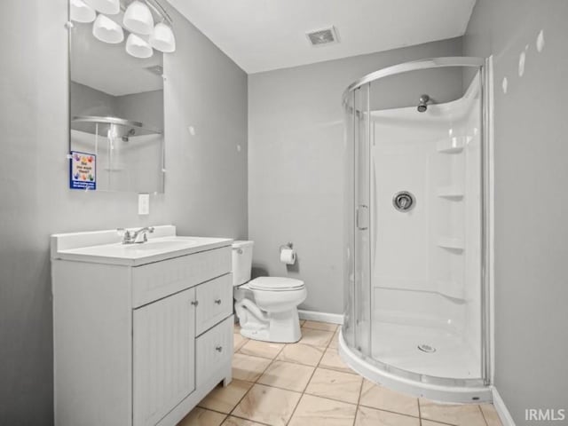 bathroom with a shower stall, vanity, toilet, and baseboards