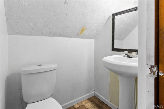 510 W Washington St, Oakland City, IN 47660 - half bathroom with vaulted ceiling, wood finished floors, a textured ceiling, toilet, and baseboards