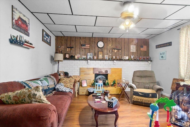 510 W Washington St, Oakland City, IN 47660 - living area featuring a ceiling fan, wood finished floors, a paneled ceiling, wood walls, and an accent wall