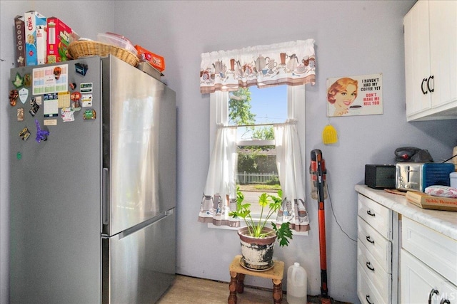 510 W Washington St, Oakland City, IN 47660 - kitchen featuring freestanding refrigerator, white cabinetry, and light countertops